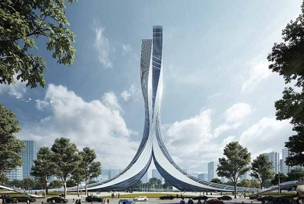 Tall monument in a park with trees and buildings in the background