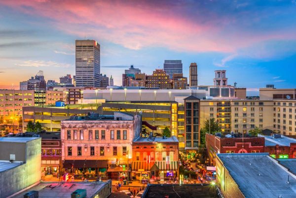 Cityscape of dowtown Memphis, Tennessee at sunset. Focus on orange glow of street lights and red/pink hue of sunset and brick buildings