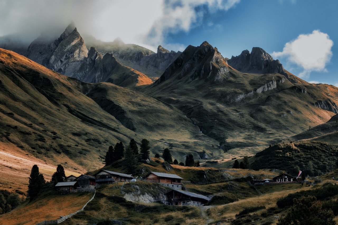 small cluster of buildings at the foot of a mountain range